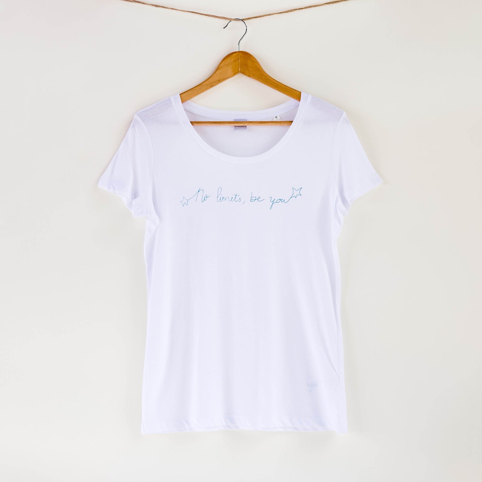 Camiseta blanca de mujer, de algodón orgánico y estampada a mano con tintas ecológicas. Texto estampado en color naranja.