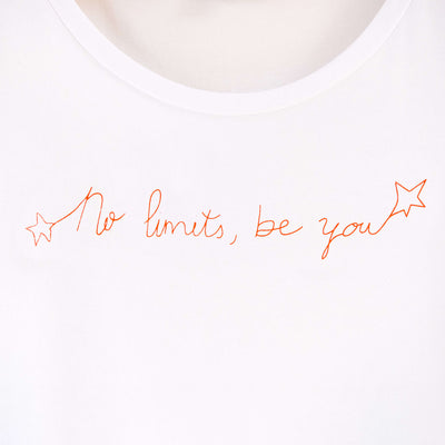 Detalle de texto estampado en color naranja. Camiseta blanca de mujer, de algodón orgánico y estampada a mano con tintas ecológicas.